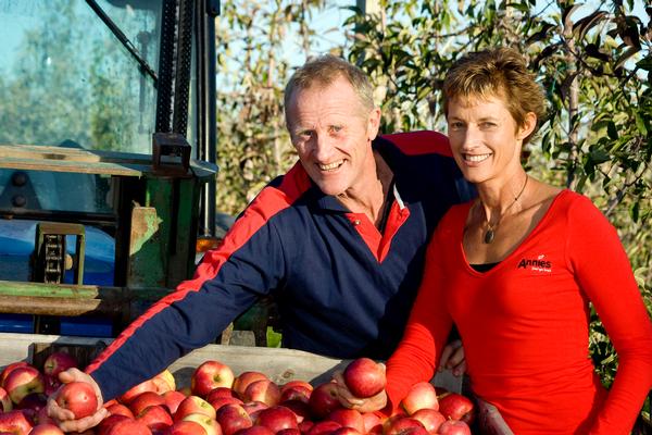 Ann and Graeme Giles in the orchard with apples
